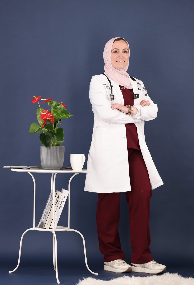 د. هبه سرحان بذراعين متقاطعتين أمام خلفية كحلية
